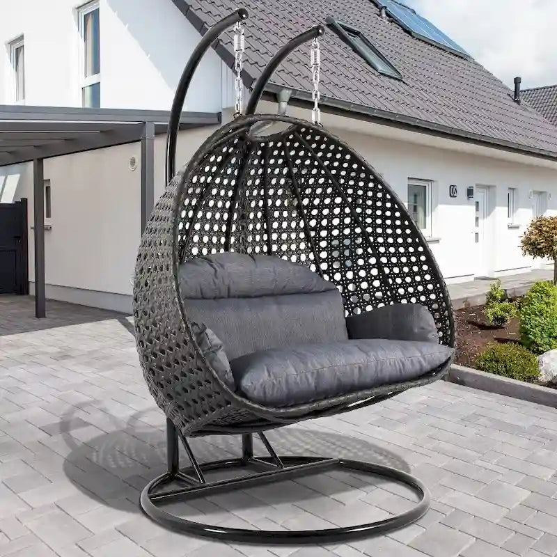 LeisureMod Hängesessel in Ei-Form für 2 Personen mit Gestell - Rattan-Pendelsessel für drinnen und draußen, Hängemattensessel für die Terrasse mit Kissen