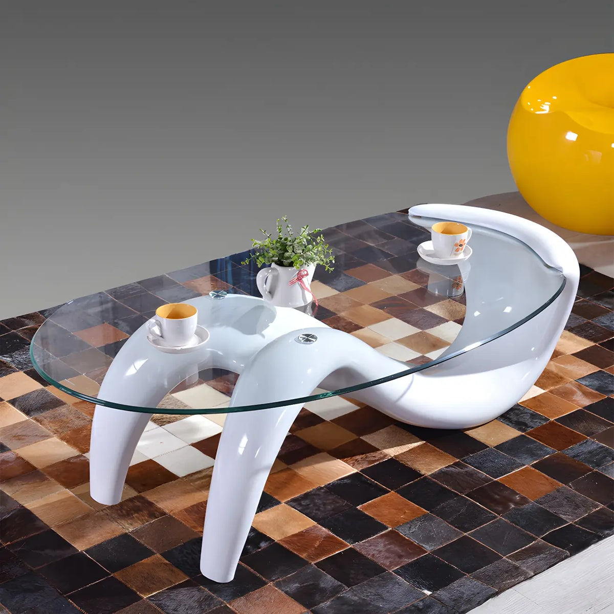 Abstracte moderne salontafel met ovaal glazen blad en metalen onderstel