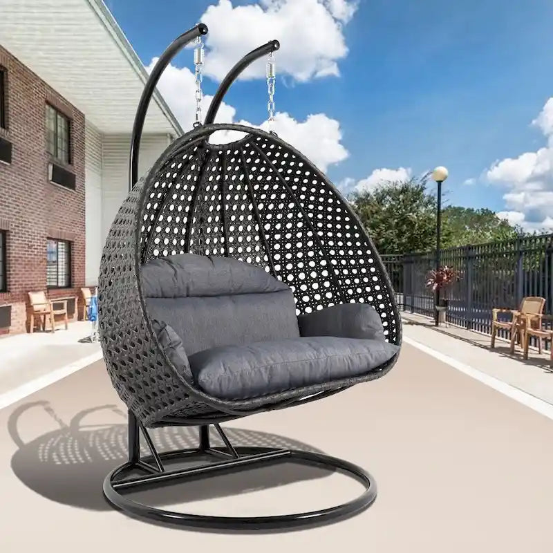 LeisureMod Hängesessel in Ei-Form für 2 Personen mit Gestell - Rattan-Pendelsessel für drinnen und draußen, Hängemattensessel für die Terrasse mit Kissen