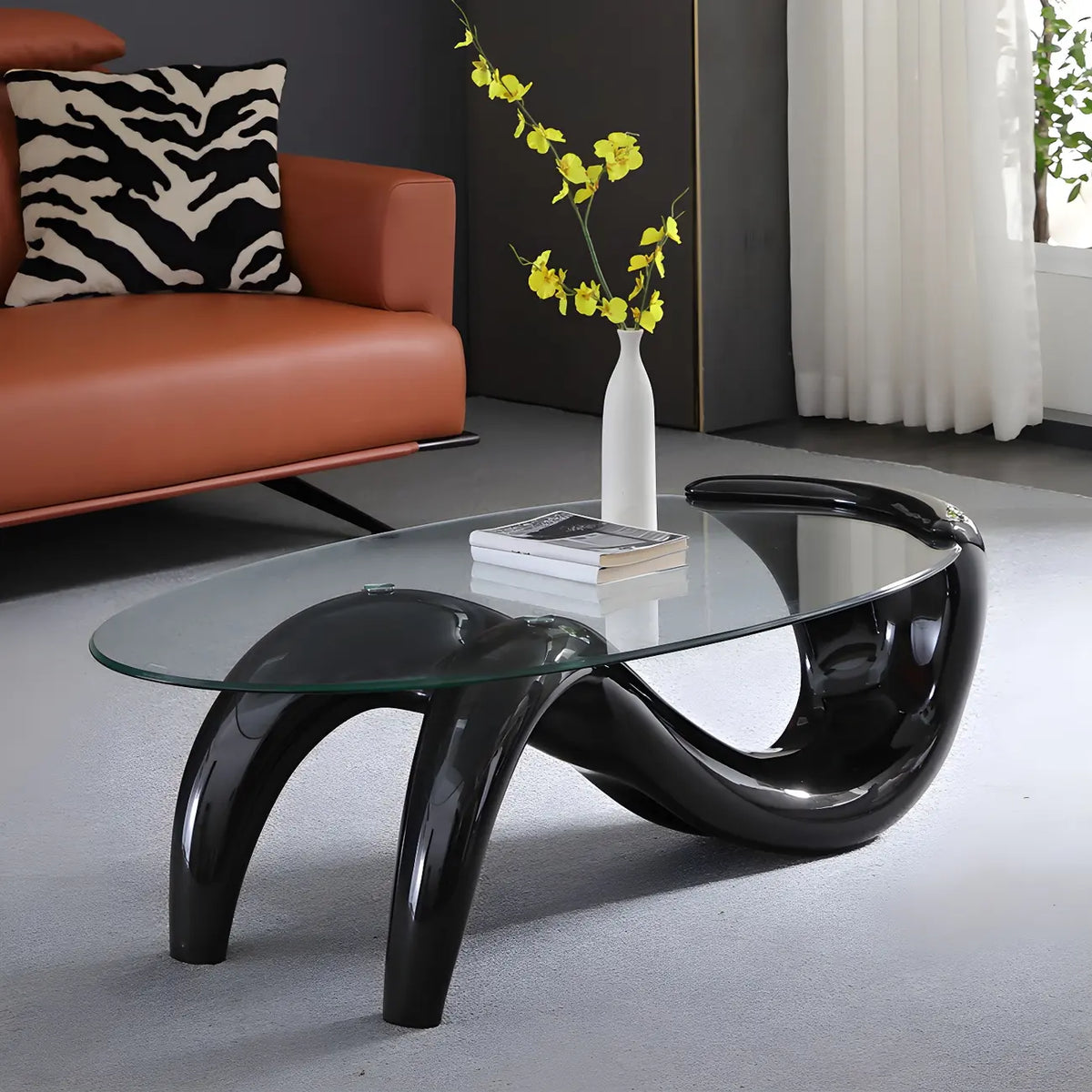 Abstracte moderne salontafel met ovaal glazen blad en metalen onderstel